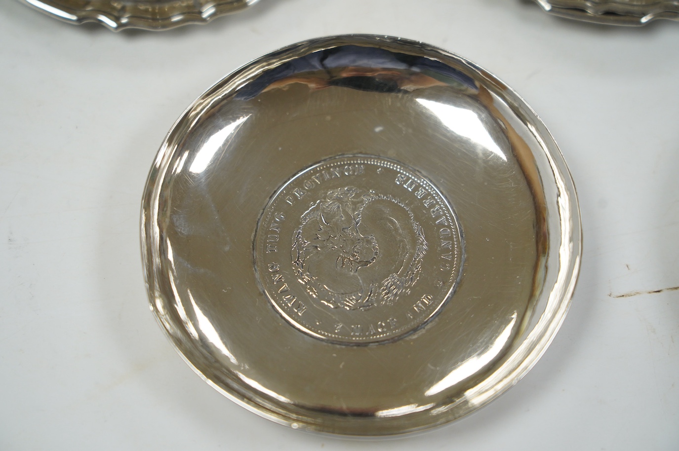 A pair of George V silver pedestal bonbon dishes, Birmingham, 1916, diameter 12.7cm, a set of four similar silver glass coasters, a silver bonbon bowl and a pair of Chinese white metal dishes with inset coin bases by Wan